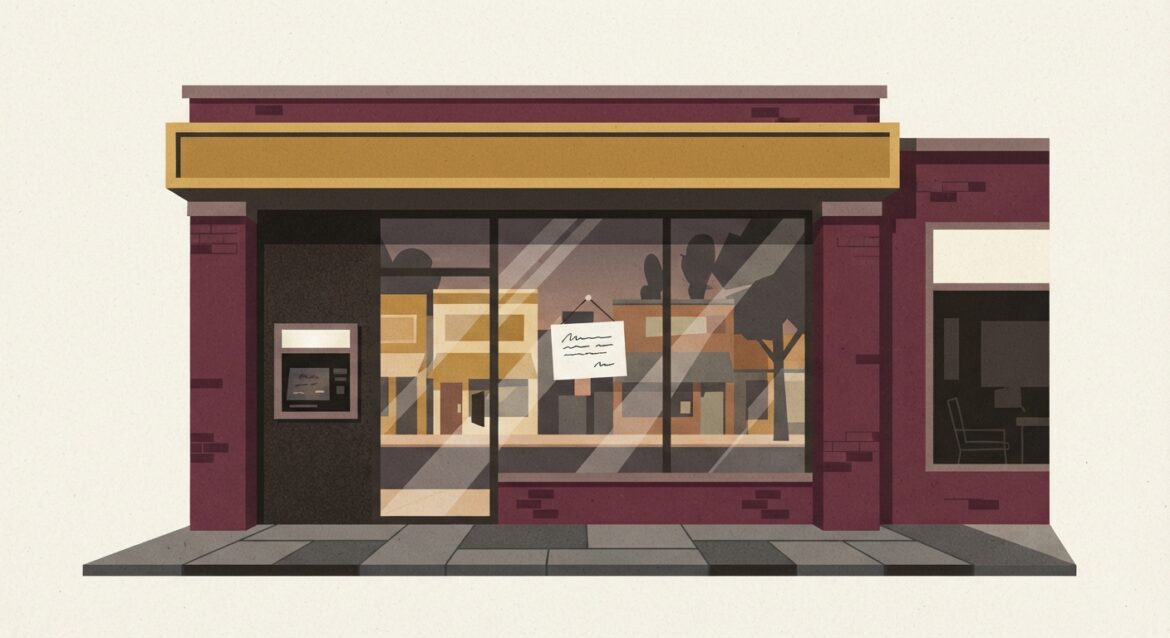 An empty small-town bank branch storefront with a 'For Lease' sign, main street reflected in the glass