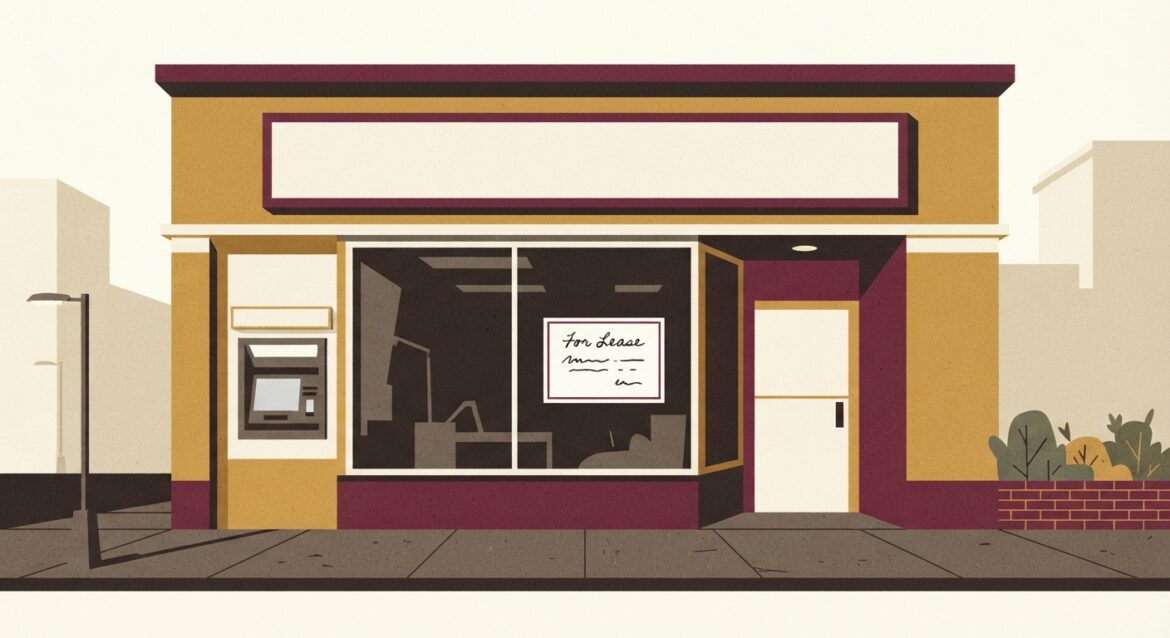 A closed bank branch storefront with a For Lease sign in a small town